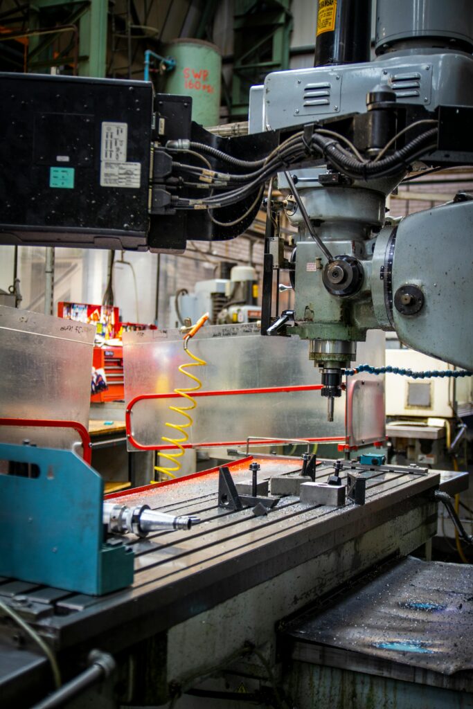 Close-up of an industrial CNC lathe in a bustling machine shop setting, focused on precision metalwork.